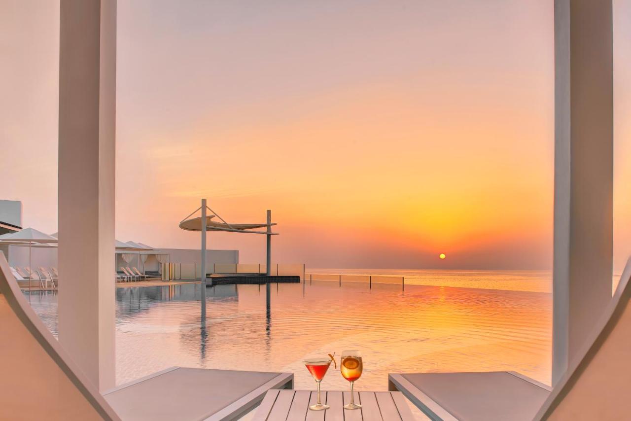 Royal M Al Aqah Beach Resort By Gewan Eksteriør billede Sunset at the pool